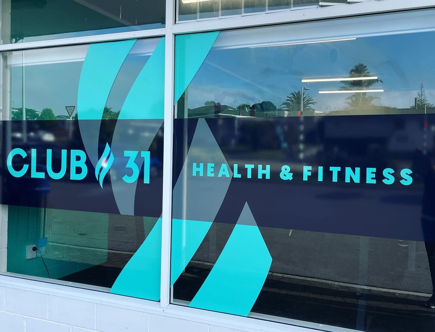 Club 31 Health and Fitness window signage on Tilby Drive, teal on deep navy